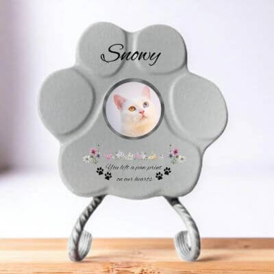 Lápida con forma de huella de piedra personalizada en gris tamaño pequeno, con soporte. Incluye ejemplo con la foto de tu gato, su nombre y un Mensaje. Un recuerdo único y emotivo para honrar su memoria.