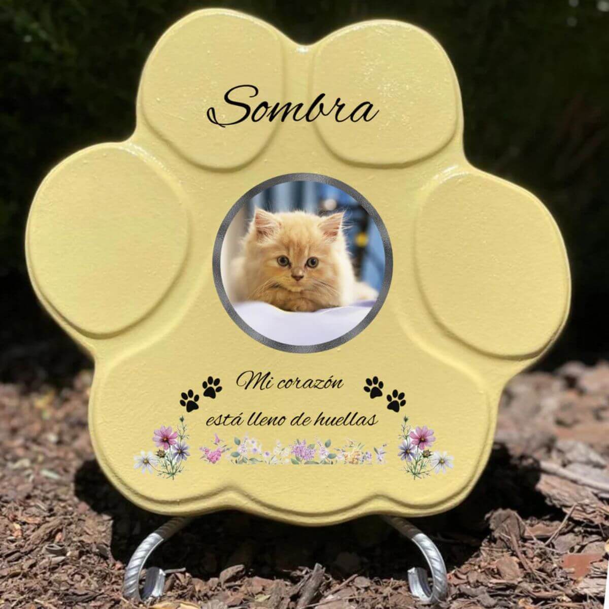 Lápida con forma de huella de piedra personalizada en amarillo tamaño grande, con soporte. Incluye ejemplo con la foto de tu gato, su nombre y un Mensaje. Un recuerdo único y emotivo para honrar su memoria.

