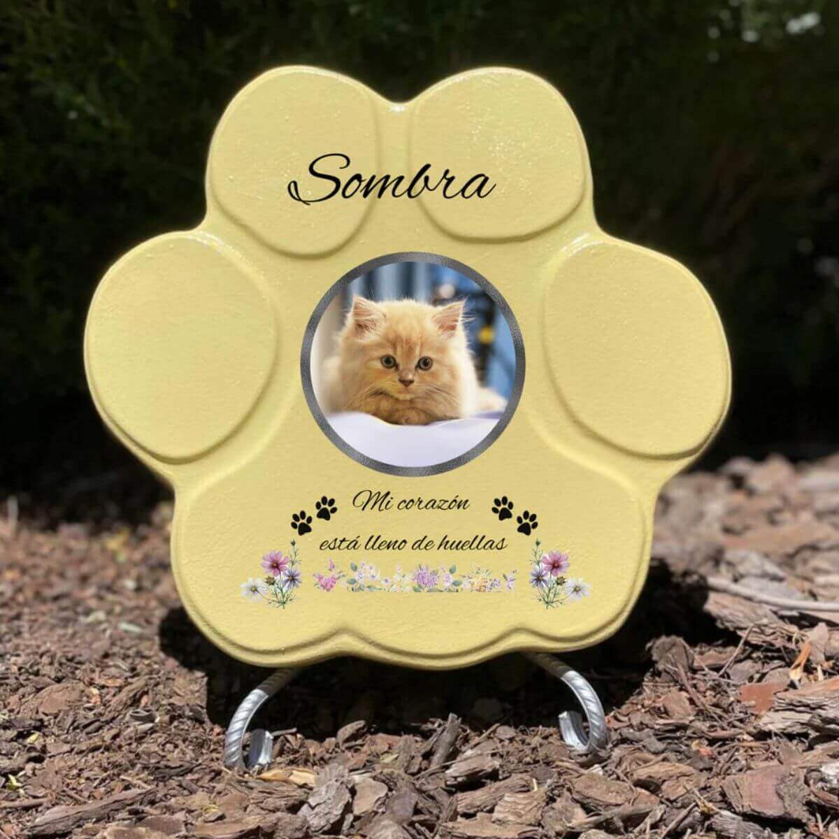 Lápida con forma de huella de piedra personalizada en amarillo tamaño mediano, con soporte. Incluye ejemplo con la foto de tu gato, su nombre y un Mensaje. Un recuerdo único y emotivo para honrar su memoria.

