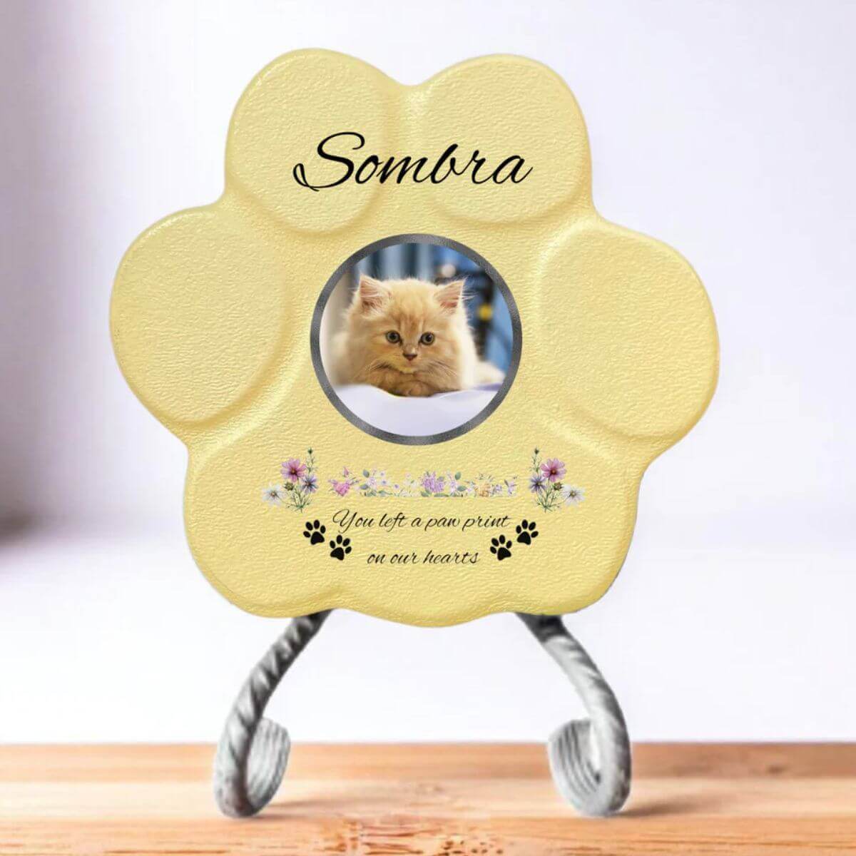 Lápida con forma de huella de piedra personalizada en amarillo tamaño pequeno, con soporte. Incluye ejemplo con la foto de tu gato, su nombre y un Mensaje. Un recuerdo único y emotivo para honrar su memoria.