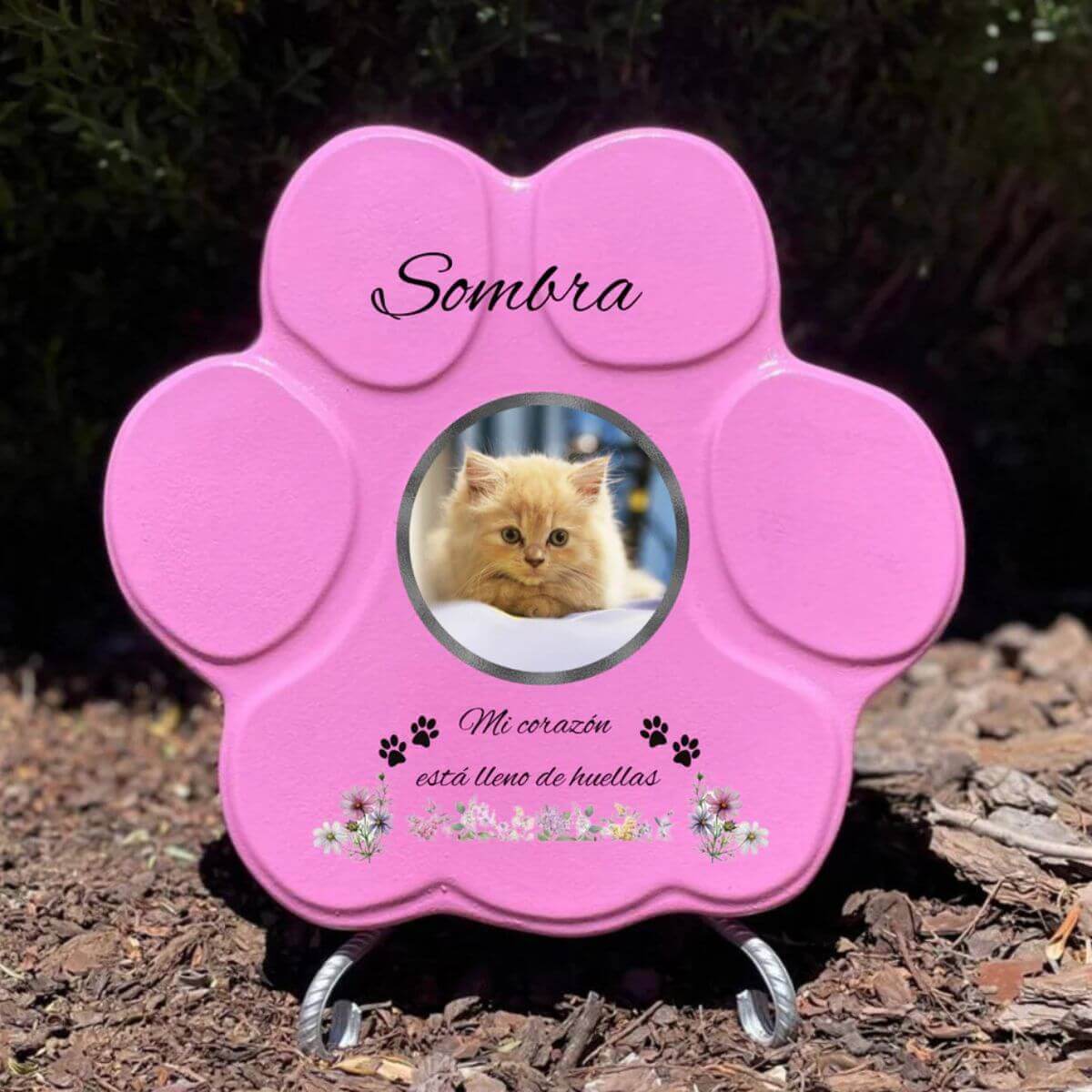Lápida con forma de huella de piedra personalizada en rosa tamaño mediano, con soporte. Incluye ejemplo con la foto de tu gato, su nombre y un Mensaje. Un recuerdo único y emotivo para honrar su memoria.

