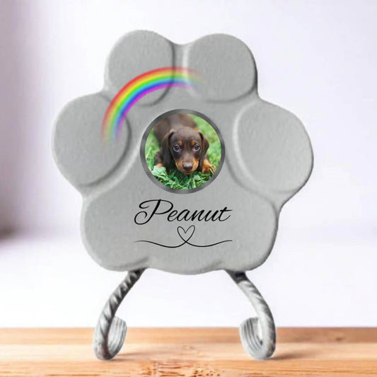 Huella de piedra conmemorativa personalizada en color gris, tamaño pequeño, sobre un soporte. Muestra un ejemplo con la foto de una mascota, su nombre y un arcoíris.