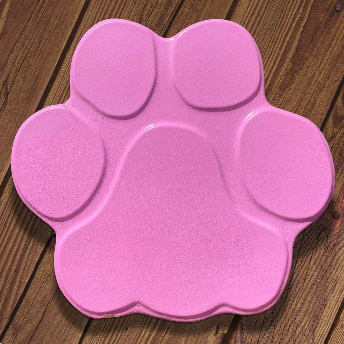 Vista frontal de una huella de hormigón rosa pintada, ideal como baldosa decorativa o conmemorativa para jardín.