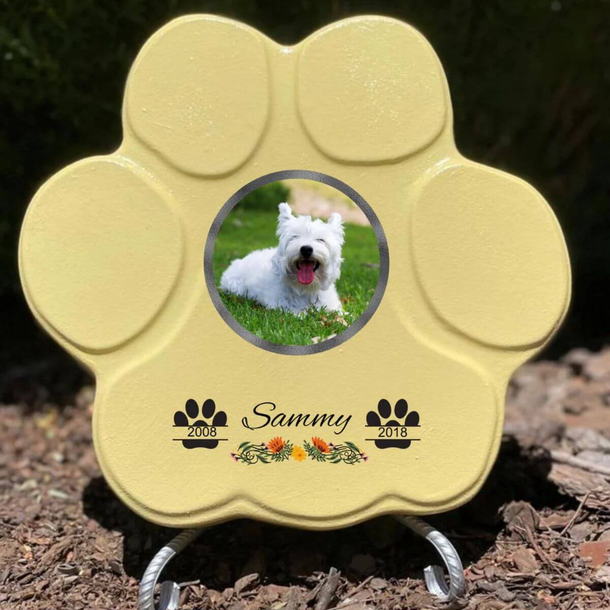 Lápida con forma de huella para mascotas, hecha de piedra , tamaño grande amarillo con soporte. Personalizada con foto, nombre y fechas importantes del perro o gato. Ejemplo de homenaje conmemorativo único.

