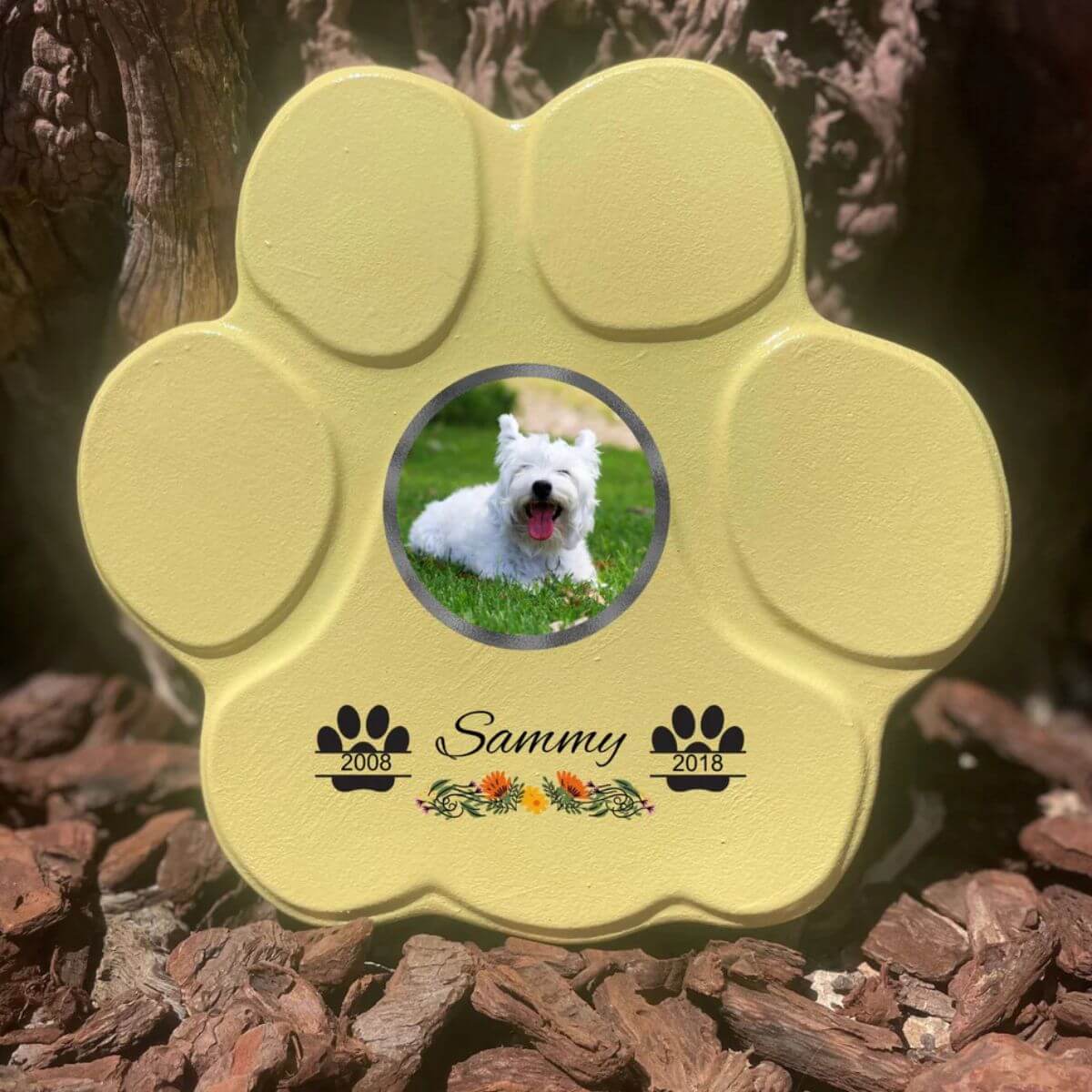 Lápida con forma de huella para mascotas, hecha de piedra amarillo, tamaño mediano sin soporte. Personalizada con foto, nombre y fechas importantes del perro o gato. Ejemplo de homenaje conmemorativo único.


