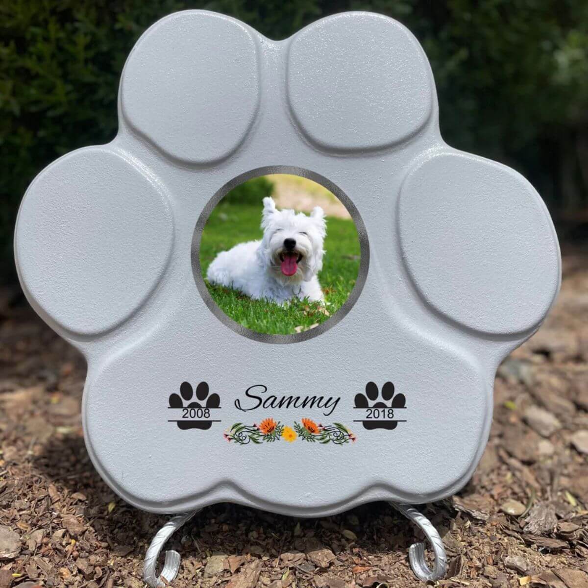 Lápida con forma de huella para mascotas, hecha de piedra , tamaño grande gris con soporte. Personalizada con foto, nombre y fechas importantes del perro o gato. Ejemplo de homenaje conmemorativo único.