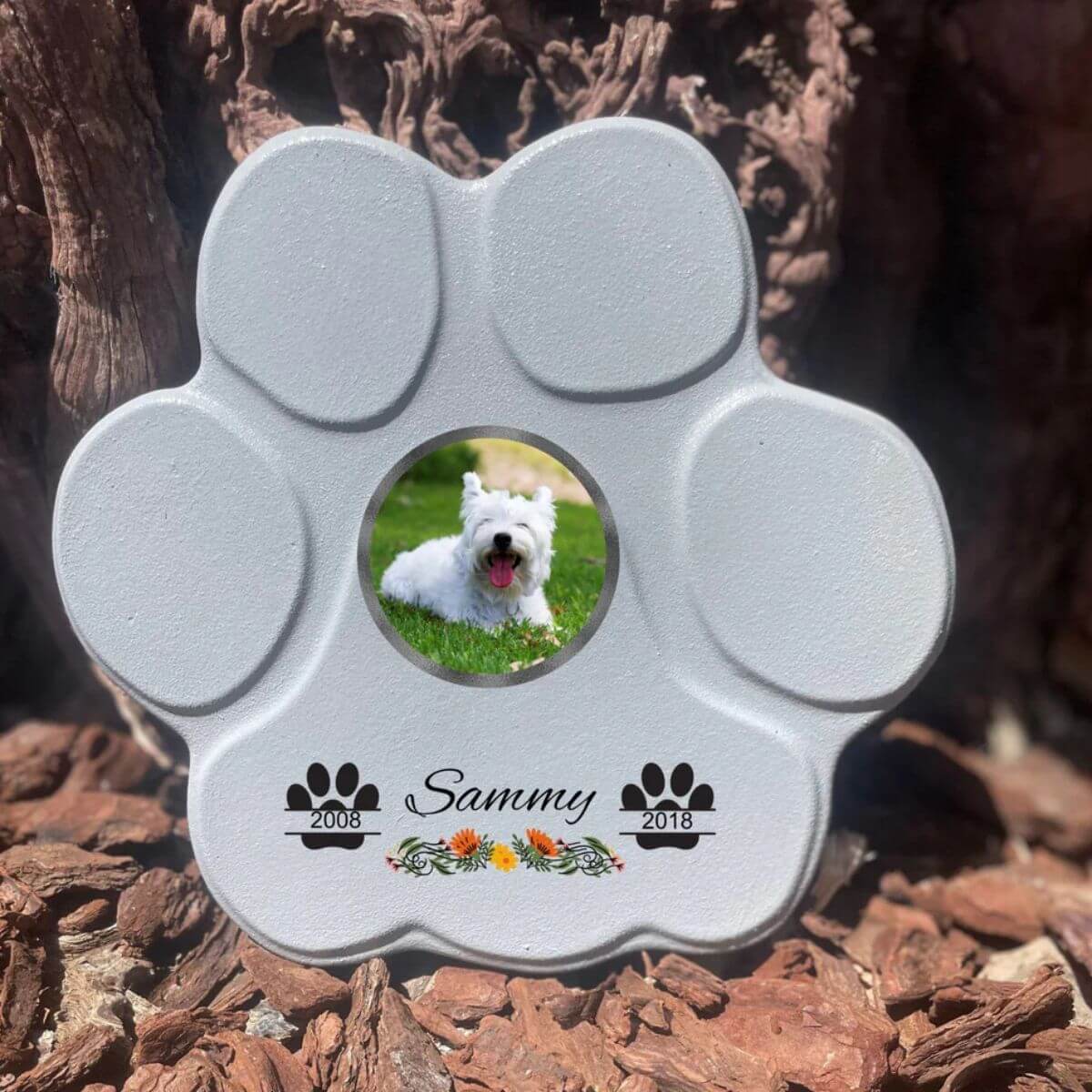 Lápida con forma de huella para mascotas, hecha de piedra gris, tamaño mediano sin soporte. Personalizada con foto, nombre y fechas importantes del perro o gato. Ejemplo de homenaje conmemorativo único.

