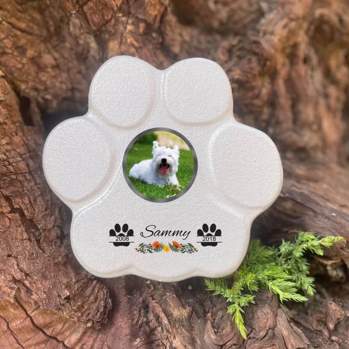 Lápida con forma de huella para mascotas, hecha de piedra gris, tamaño pequeño sin soporte. Personalizada con foto, nombre y fechas importantes del perro o gato. Ejemplo de homenaje conmemorativo único.