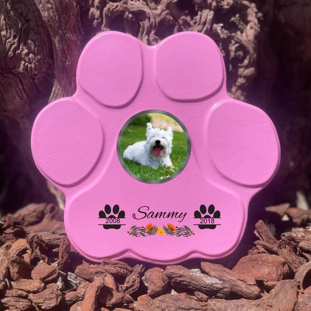 Lápida con forma de huella para mascotas, hecha de piedra rosa, tamaño mediano sin soporte. Personalizada con foto, nombre y fechas importantes del perro o gato. Ejemplo de homenaje conmemorativo único.

