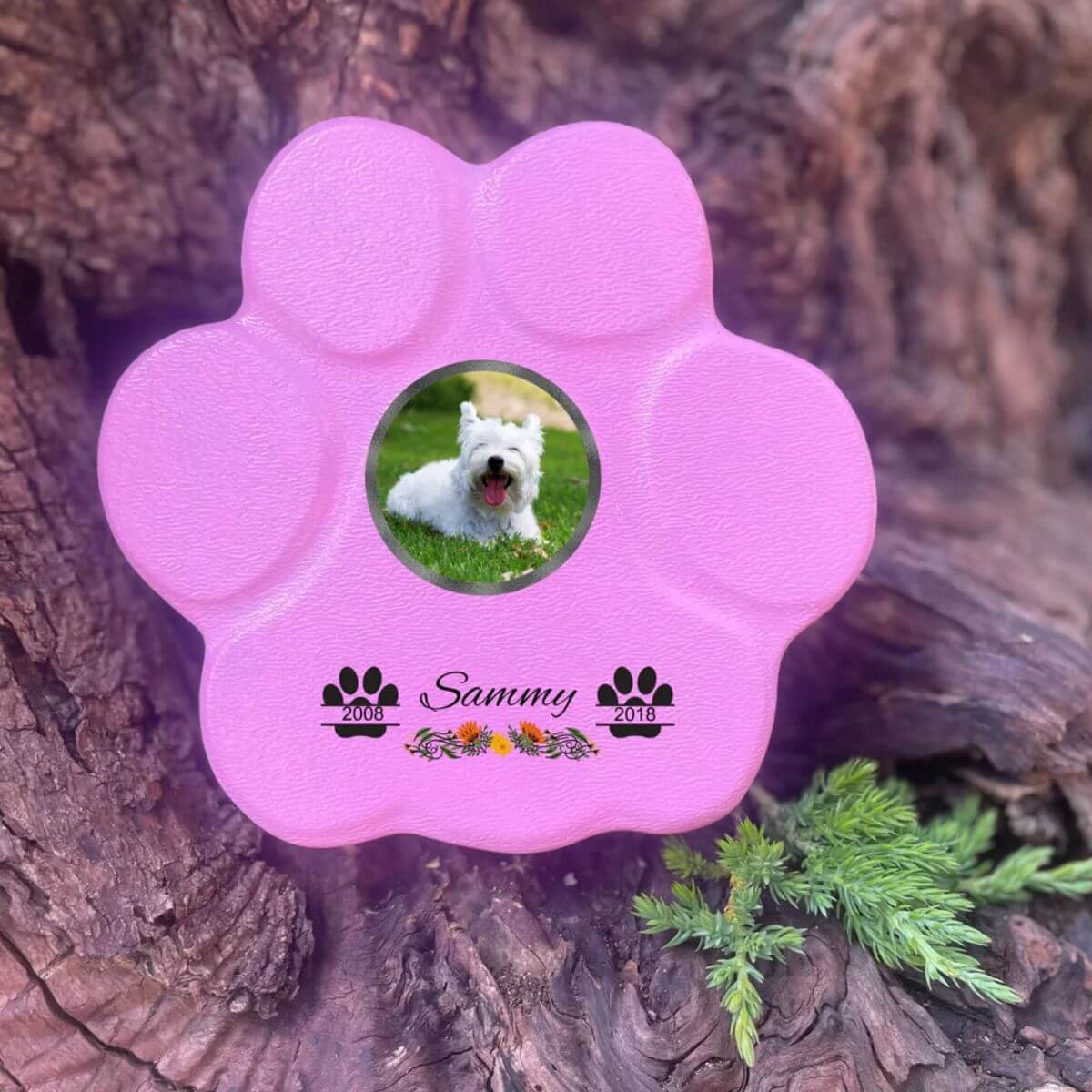 Lápida con forma de huella para mascotas, hecha de piedra rosa, tamaño pequeño sin soporte. Personalizada con foto, nombre y fechas importantes del perro o gato. Ejemplo de homenaje conmemorativo único.