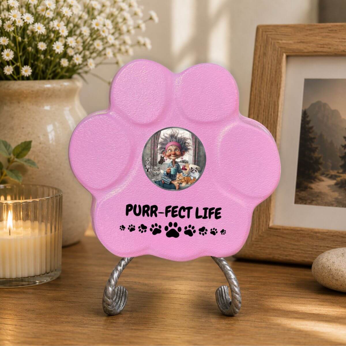 Placa decorativa artesanal en color rosa con diseño Purr-fect Life sobre una mesa como decoración del hogar