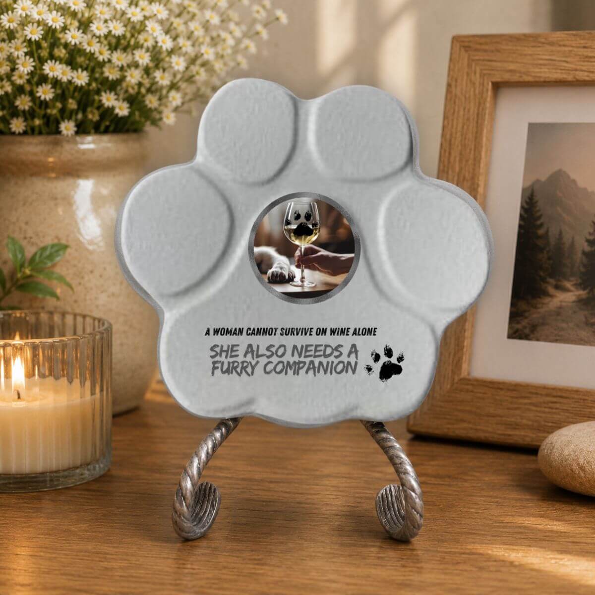 Placa divertida de hormigón con soporte opcional para amantes de los perros con la frase en inglés "A Woman Cannot Survive on Wine Alone, She Also Needs a Furry Companion" expuesta en el interior de un hogar en color gris.