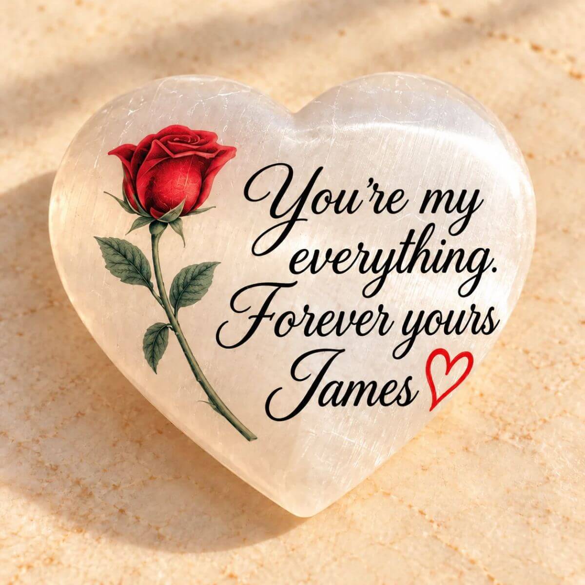 Reverso del corazón de selenita personalizado con una rosa roja, el mensaje en inglés «You’re my everything. Forever yours, James» y un pequeño corazón rojo.