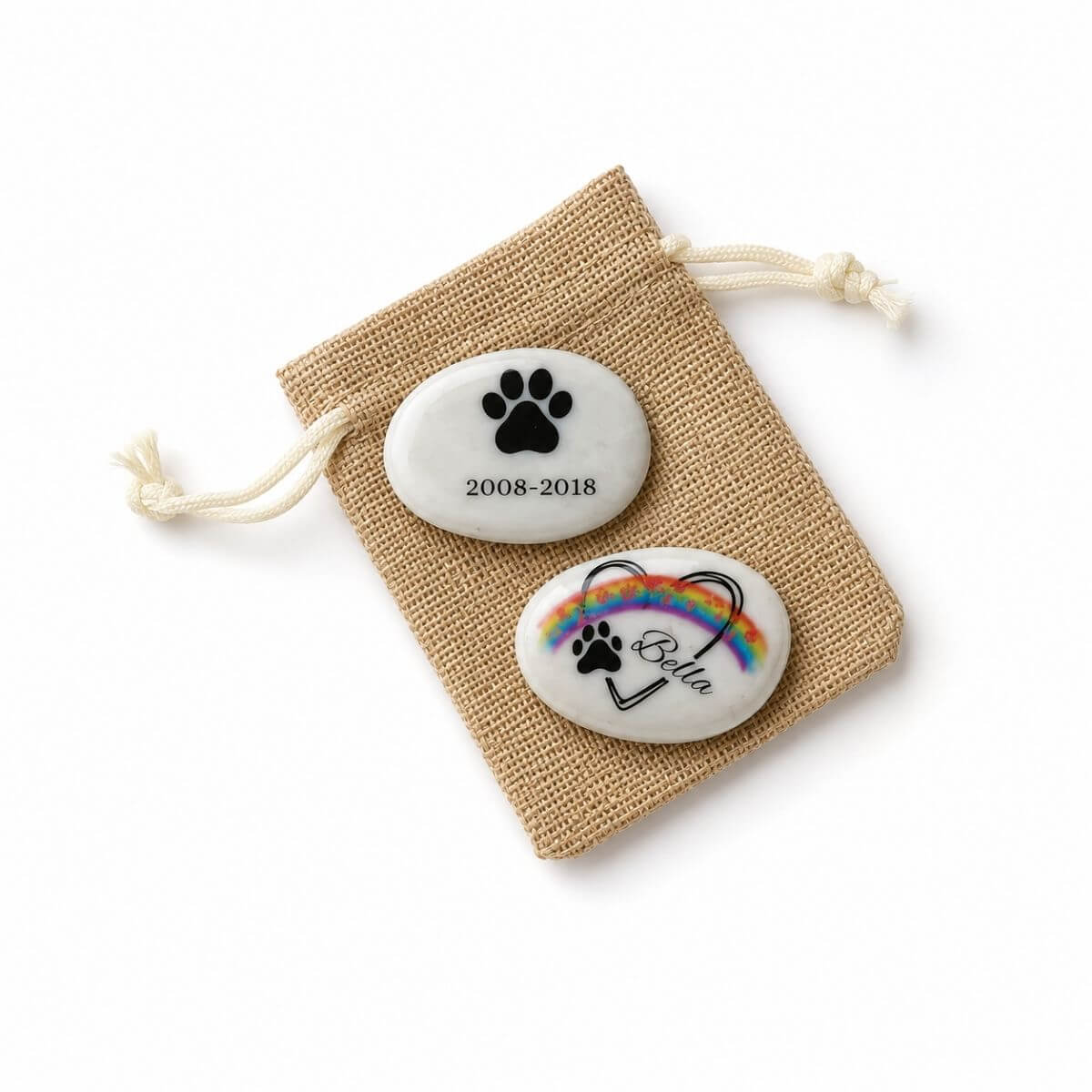 Guijarros de cristal personalizados para mascota con nombre Bella, diseño arcoíris, huella y fechas de recuerdo sobre bolsa de regalo