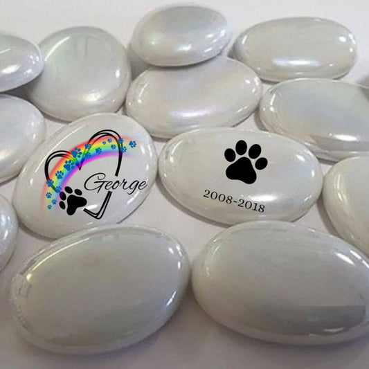 Guijarro de cristal personalizado con huellas azules, arcoíris y nombre George, junto a diseño con huella negra y fechas 2008–2018. Recuerdo conmemorativo para mascotas.
