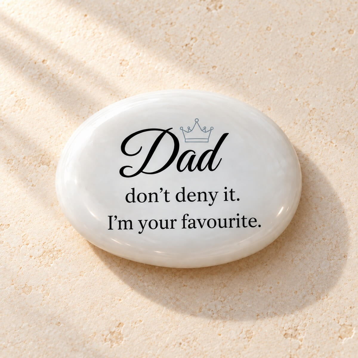Parte frontal de piedra personalizada para papá en inglés con «Dad, don’t deny it. I’m your favourite» y corona gris azulada sobre cristal blanco perlado.