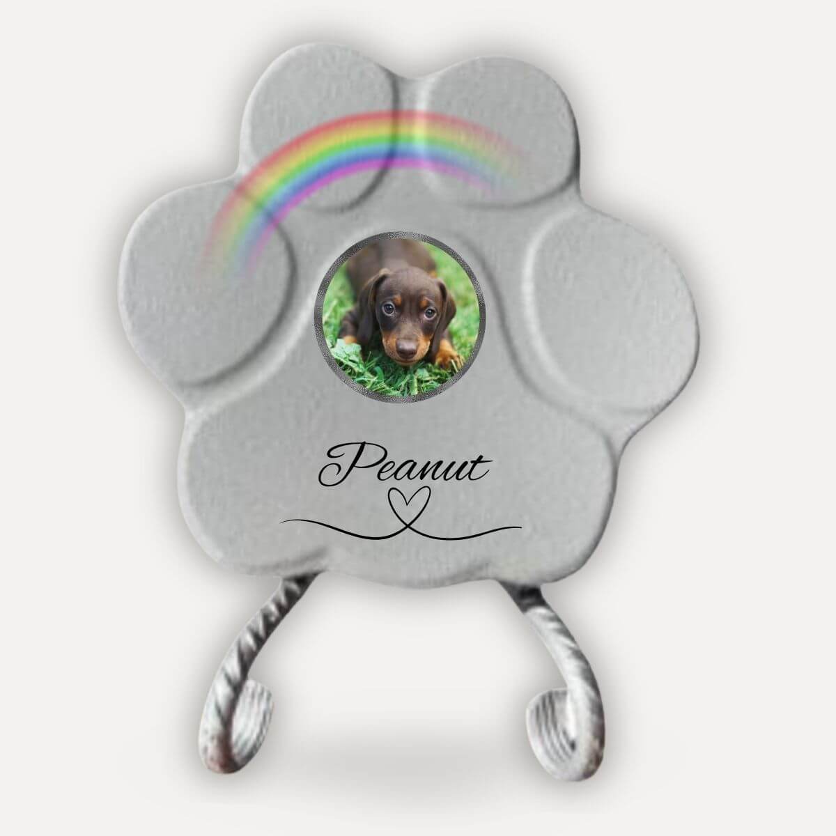 Placa memorial para perro con foto personalizada en forma de huella gris sobre soporte decorativo con arcoíris